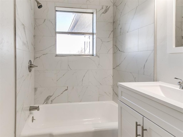 bathroom featuring tiled shower / bath combo and vanity