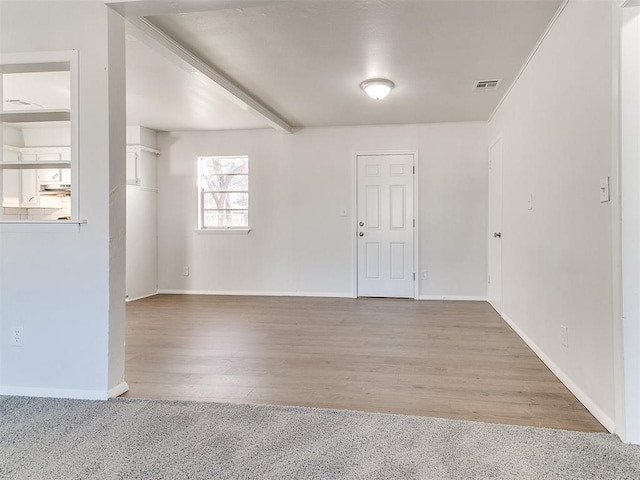 spare room with beam ceiling and carpet floors