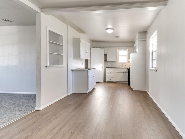 kitchen featuring decorative backsplash, light wood-type flooring, sink, built in features, and white fridge