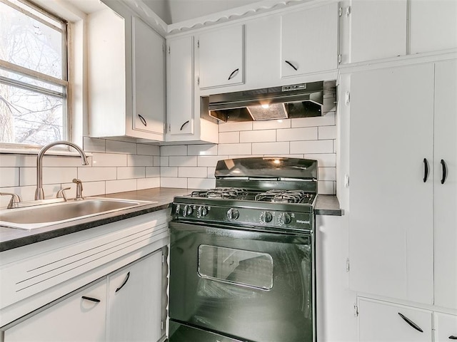 kitchen featuring black gas range, backsplash, white cabinetry, and sink