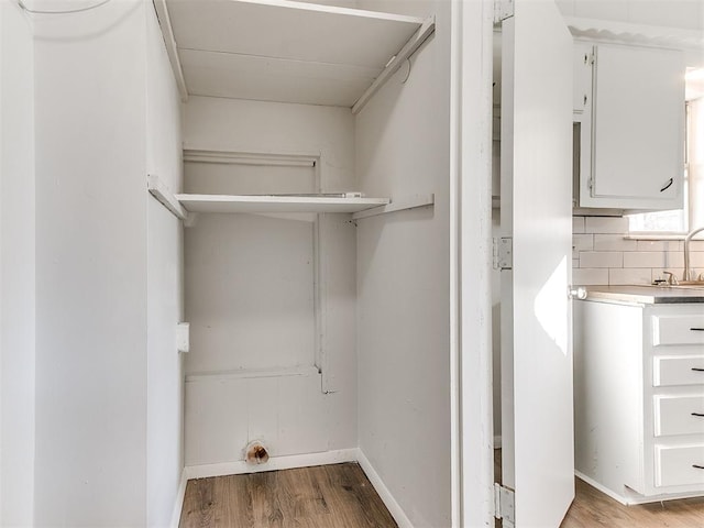 clothes washing area with hardwood / wood-style floors and sink