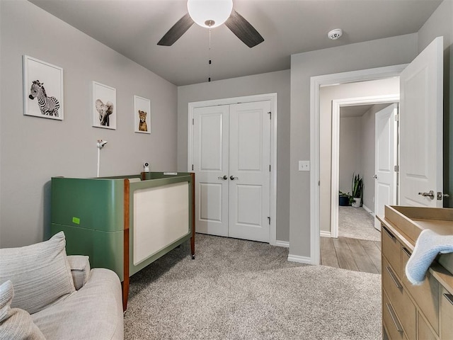 bedroom featuring ceiling fan, sink, light carpet, and a closet