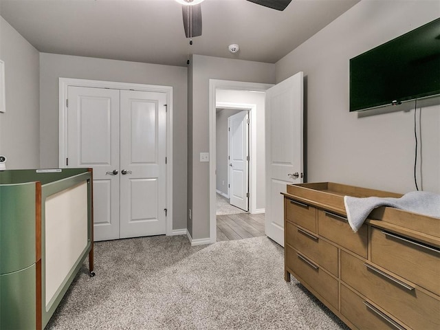 carpeted bedroom with ceiling fan and a closet