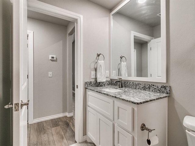 bathroom featuring vanity, hardwood / wood-style flooring, and toilet