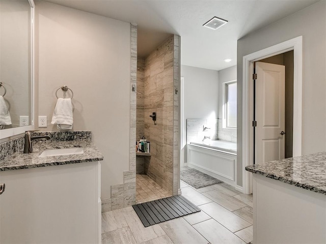 bathroom with shower with separate bathtub and vanity