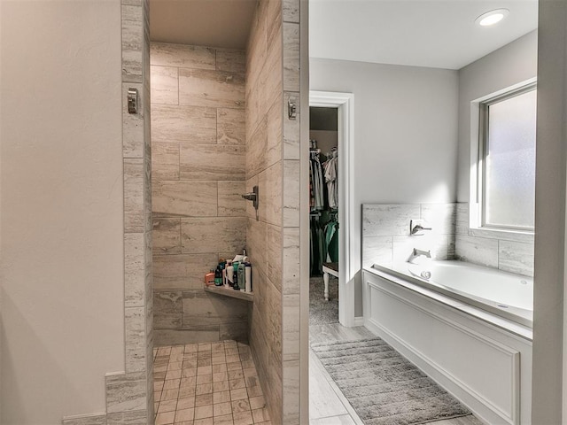 bathroom with a tub to relax in and hardwood / wood-style flooring