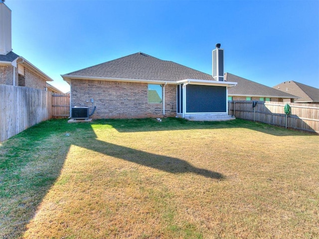 back of house with cooling unit and a yard