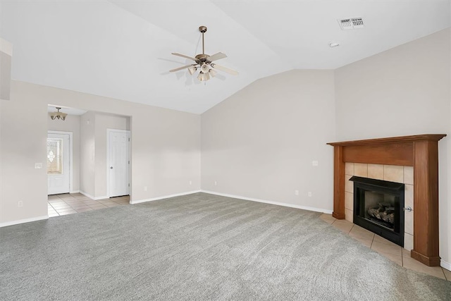 unfurnished living room with light colored carpet, vaulted ceiling, ceiling fan, and a tiled fireplace