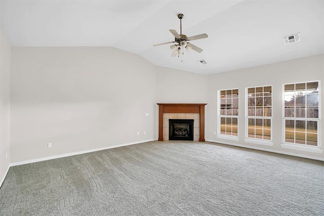 unfurnished living room featuring a tile fireplace, carpet, vaulted ceiling, and ceiling fan