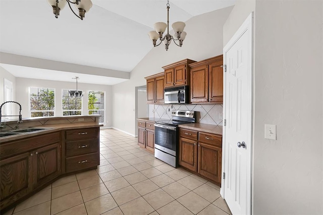 kitchen with sink, a chandelier, pendant lighting, decorative backsplash, and appliances with stainless steel finishes