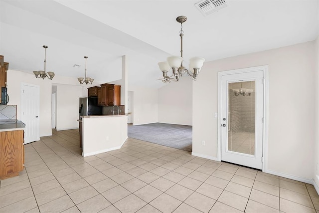 kitchen featuring sink, an inviting chandelier, stainless steel fridge, light colored carpet, and pendant lighting