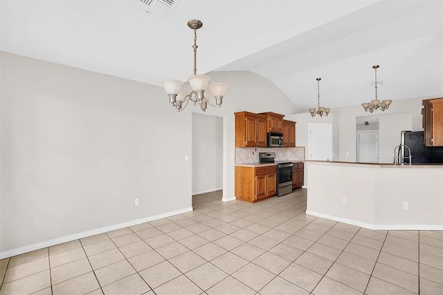 kitchen featuring tasteful backsplash, lofted ceiling, decorative light fixtures, light tile patterned floors, and appliances with stainless steel finishes