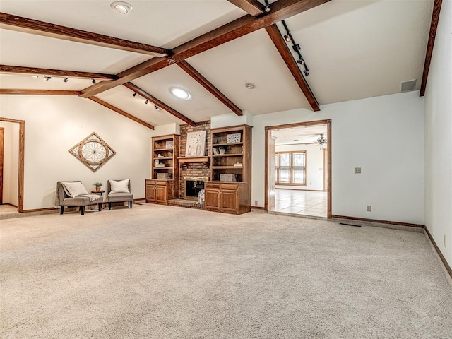 unfurnished living room featuring light carpet, vaulted ceiling with beams, a fireplace, and ceiling fan