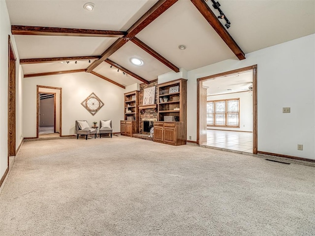 unfurnished living room with vaulted ceiling with beams, light colored carpet, and a brick fireplace