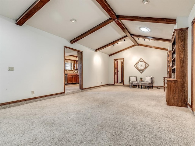 unfurnished living room with vaulted ceiling with beams and light carpet