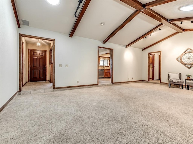 carpeted spare room with vaulted ceiling with beams