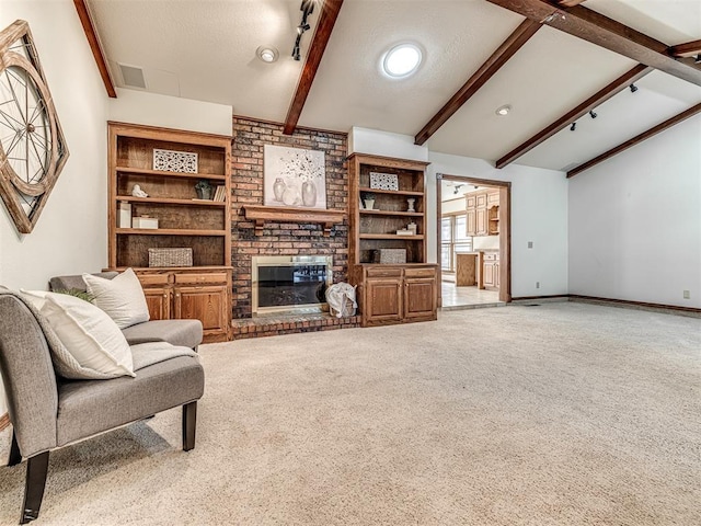 carpeted living room featuring a textured ceiling, rail lighting, a brick fireplace, and vaulted ceiling with beams