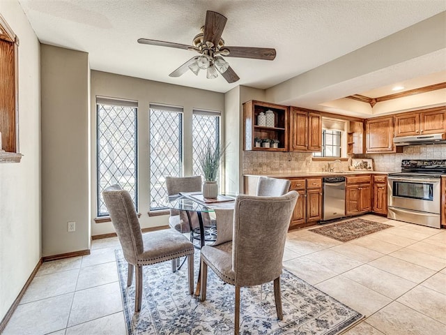 dining area with ceiling fan, sink, light tile patterned floors, and a textured ceiling