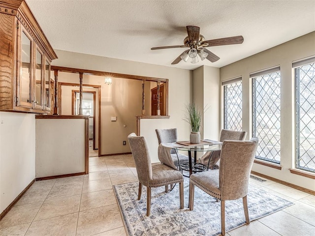 dining space featuring a wealth of natural light, light tile patterned floors, ceiling fan, and a textured ceiling