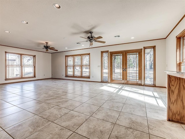 unfurnished room featuring french doors, crown molding, ceiling fan, and a healthy amount of sunlight