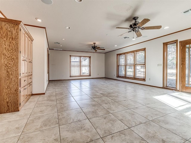 tiled empty room featuring ceiling fan and ornamental molding