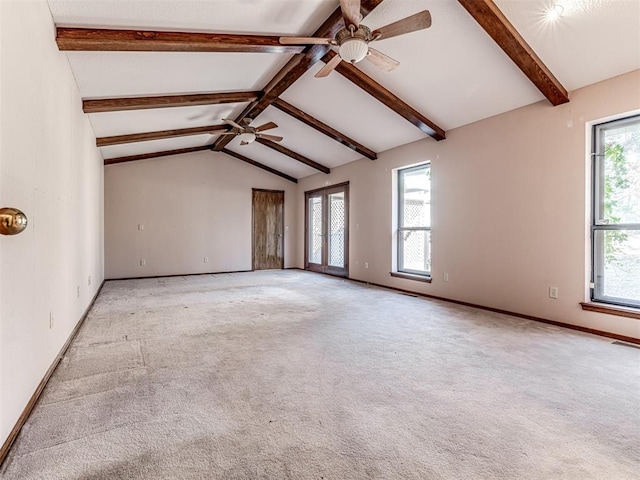 interior space with vaulted ceiling with beams, light colored carpet, a wealth of natural light, and ceiling fan