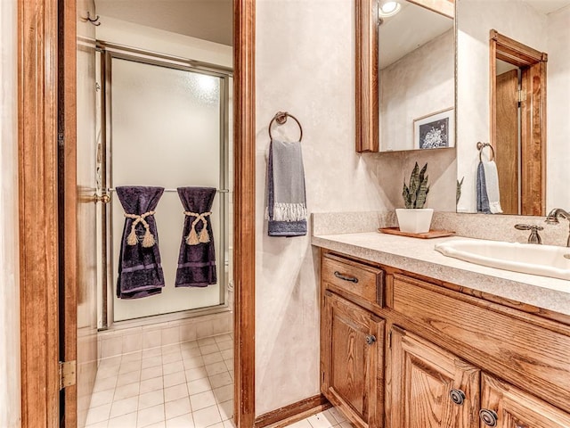 bathroom with tile patterned floors, vanity, and walk in shower