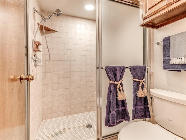 bathroom with toilet and a shower with shower door