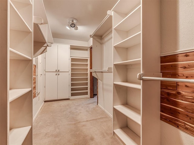 walk in closet featuring light colored carpet