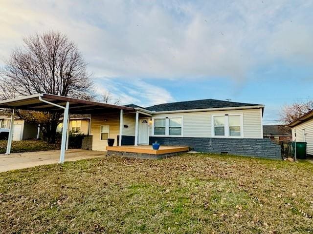 ranch-style home with a front lawn, a deck, and a carport