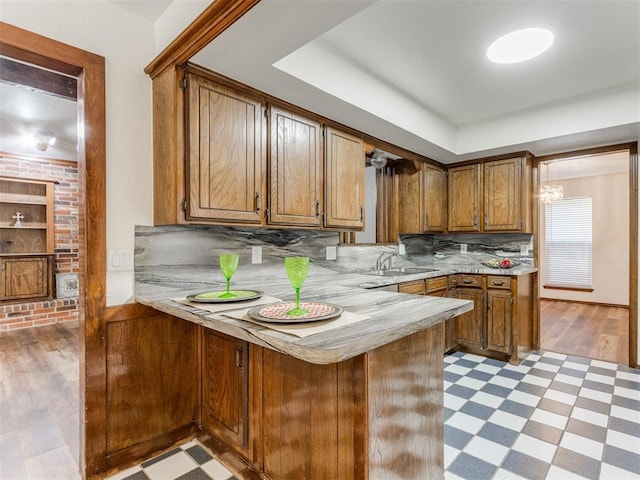 kitchen featuring kitchen peninsula, light hardwood / wood-style flooring, and sink