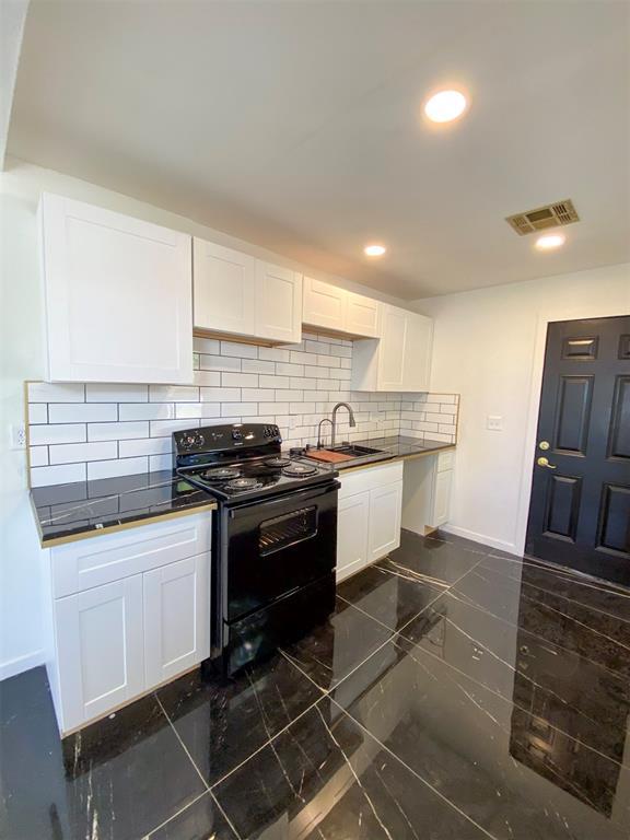 kitchen featuring white cabinetry, backsplash, electric range, and sink