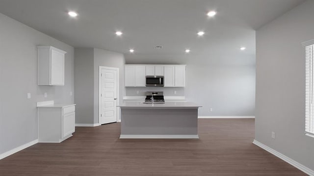 kitchen featuring an island with sink, stainless steel appliances, light countertops, white cabinetry, and a sink