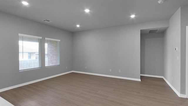 unfurnished room with recessed lighting, visible vents, baseboards, and wood finished floors