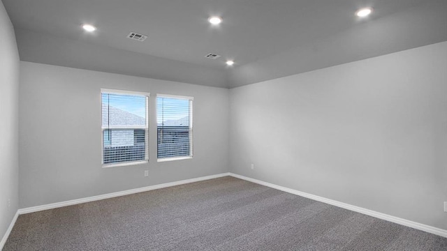 empty room featuring carpet, visible vents, and baseboards