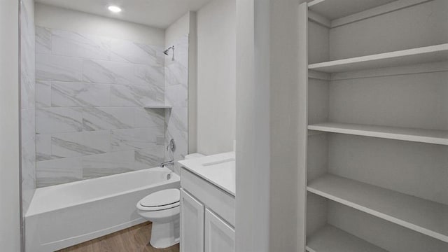 bathroom featuring bathtub / shower combination, vanity, toilet, and wood finished floors