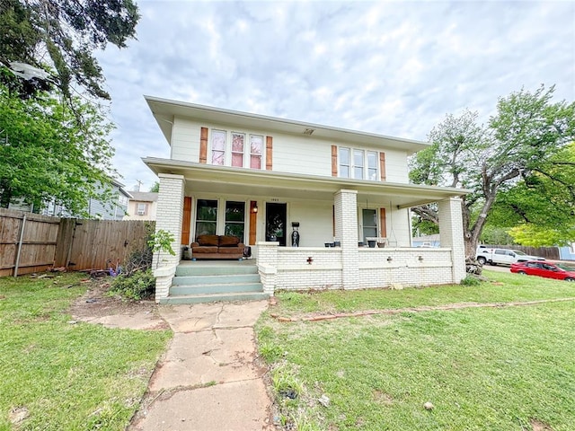 view of front of home with covered porch and a front yard