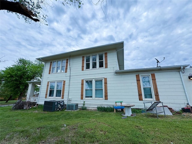 back of house featuring central AC and a lawn