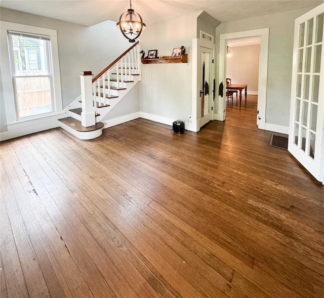 interior space featuring dark hardwood / wood-style flooring and an inviting chandelier