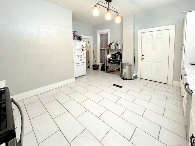 interior space featuring pendant lighting and white fridge