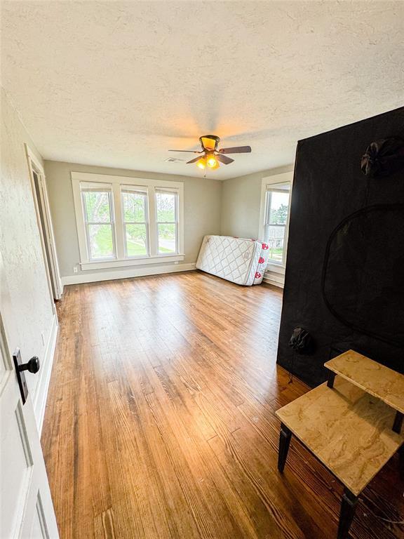 unfurnished bedroom featuring ceiling fan, a textured ceiling, and light hardwood / wood-style flooring