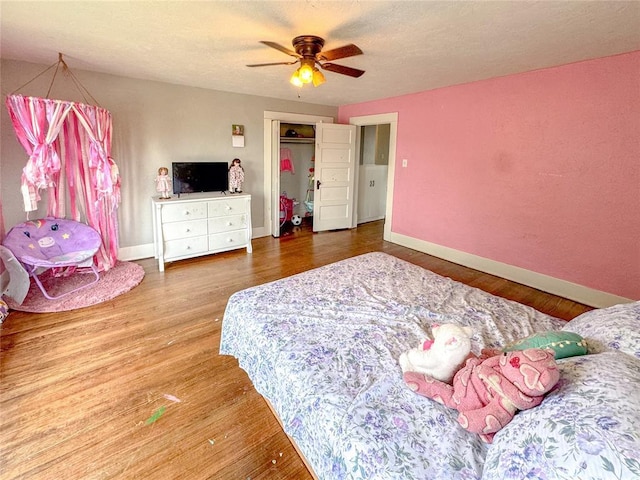 bedroom with hardwood / wood-style flooring, ceiling fan, and a closet