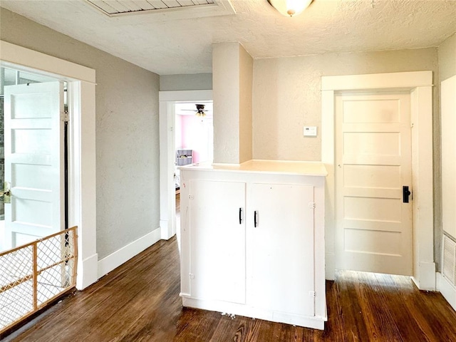 corridor with dark hardwood / wood-style flooring and a textured ceiling