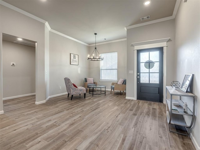 foyer entrance featuring crown molding, light hardwood / wood-style floors, and a chandelier