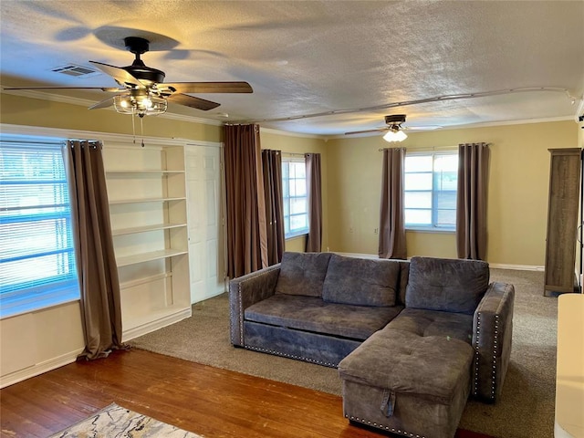 living room with a textured ceiling, hardwood / wood-style flooring, ceiling fan, and crown molding