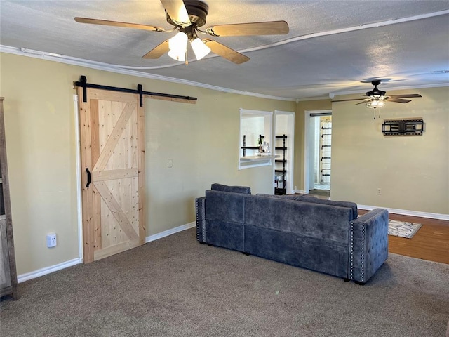 carpeted living room featuring a textured ceiling, a barn door, and crown molding