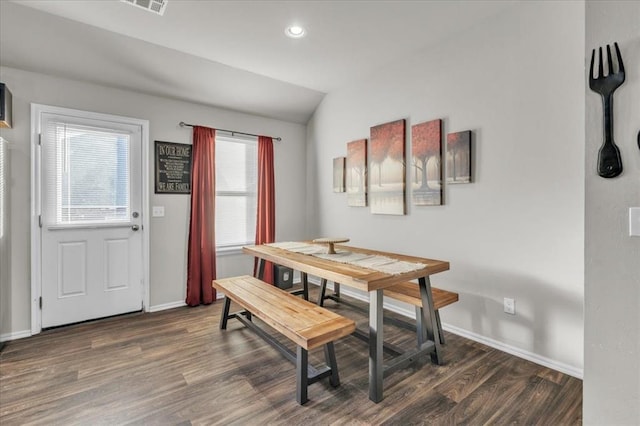 dining space with dark hardwood / wood-style flooring and vaulted ceiling