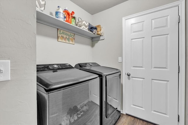 clothes washing area featuring independent washer and dryer and hardwood / wood-style flooring