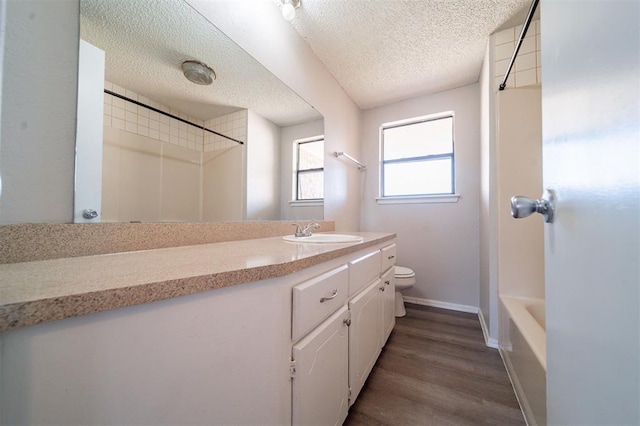 bathroom featuring vanity, hardwood / wood-style floors, a textured ceiling, and toilet