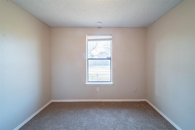 carpeted empty room with a textured ceiling